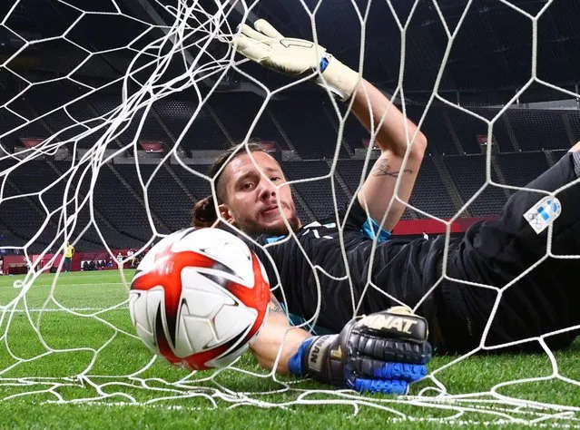 Jeremias Ledesma of Argentina falls into the back of the goal net after a shot goes over during the soccer match against Australia in Sapporo, Japan on July 22, 2021. (Photo by Kim Hong-Ji/Reuters)