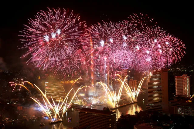 Fireworks explode over Chao Phraya River during the New Year celebrations in Bangkok, Thailand, January 1, 2019. (Photo by Athit Perawongmetha/Reuters)