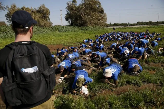 Israeli teenagers crawl through mud as they participate in an annual combat fitness training competition, as part of their preparations ahead of their compulsory army service, near Kibbutz Yakum, central Israel February 19, 2016. (Photo by Baz Ratner/Reuters)