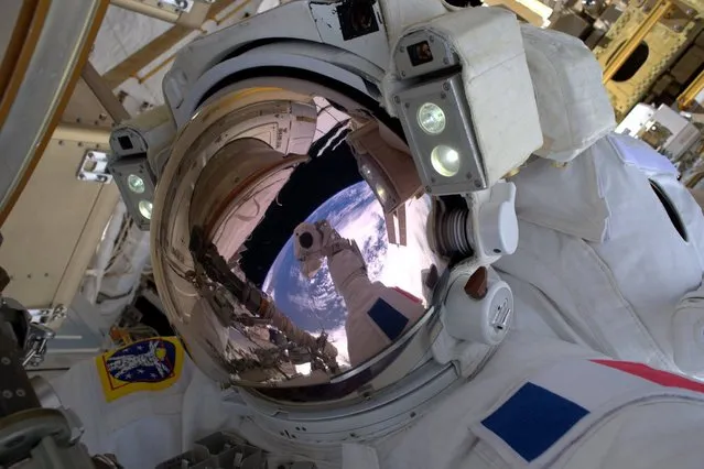 This photo made by French astronaut Thomas Pesquet of the European Space Agency shows him in a selfie photograph with the Earth reflected in his visor, during a spacewalk outside the International Space Station on Friday, January 13, 2017. Pesquet, a rookie astronaut, became France's first spacewalker in 15 years. He called it “a big day”. (Photo by Thomas Pesquet via AP Photo)