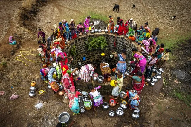 Villagers gather around a well to draw water in Telamwadi, northeast of Mumbai, India, Saturday, May 6, 2023. Collecting water from outside wells is a common task in this rural area, which has seen increasing protests as more river water from dams is diverted to urban areas. “We're very angry”, says a social worker who serves many of the 154 villages in the Thane district. “This is our rain”. (Photo by Dar Yasin/AP Photo)