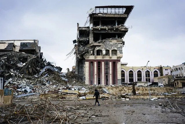An Iraqi man walks outside Mosul's University on January 22, 2017, a week after Iraqi counter-terrorism service (CTS) retook it from the Islamic State (IS) jihadists. Iraqi forces battled the last holdout jihadists in east Mosul after commanders declared victory there and quickly set their sights on the city's west, where more tough fighting awaits. (Photo by Dimitar Dilkoff/AFP Photo)