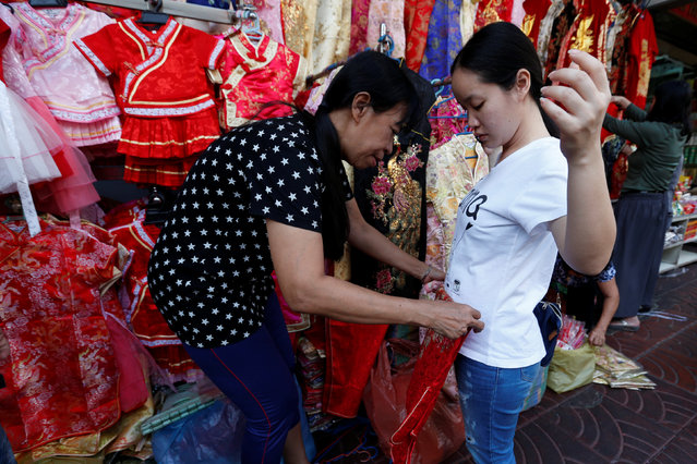 A Thai woman gets fitted for clothes to celebrate Chinese New Year in Chinatown in Bangkok, Thailand January 24, 2017. (Photo by Chaiwat Subprasom/Reuters)
