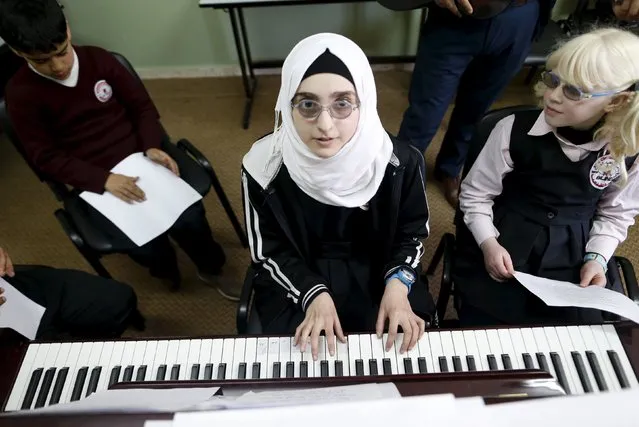 Blind and visually impaired Palestinian students attend a class, where they are taught English through song and music, at a school in the West Bank city of Hebron March 2, 2016. (Photo by Ammar Awad/Reuters)