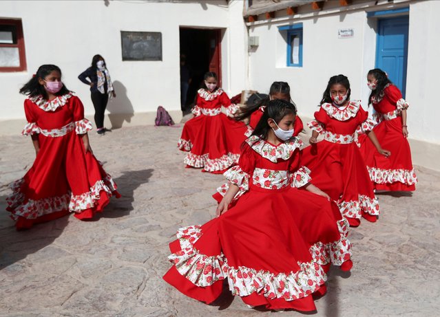 Girls practice a dance before performing at a park, in Purmamarca, Jujuy, Argentina on August 14, 2021. (Photo by Agustin Marcarian/Reuters)