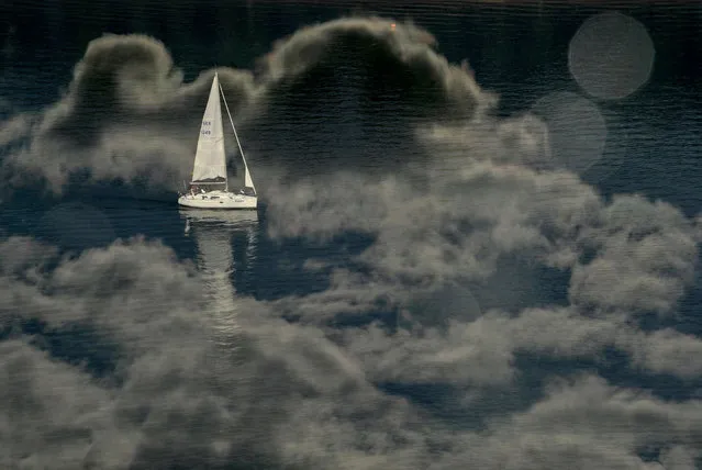 A yacht seen sailing on the Dnieper river with a reflection of the clouds in water in Kiev, Ukraine on September 5, 2021. (Photo by Sergei Chuzavkov/SOPA Images/Rex Features/Shutterstock)