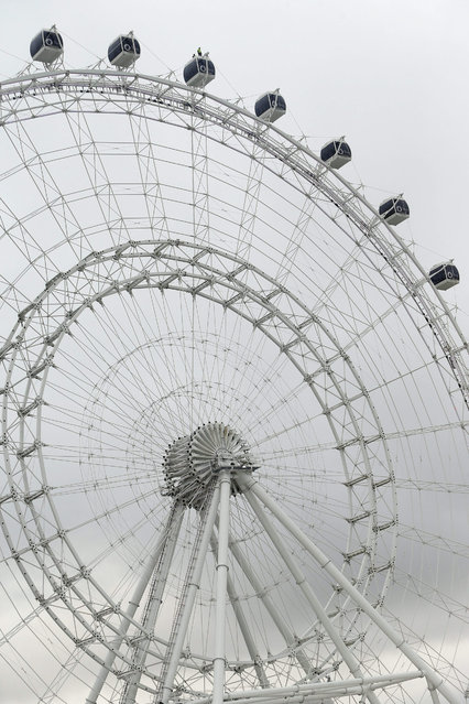 Daredevil Nik Wallenda, 36, walks untethered atop the 122m high Orlando Eye observation wheel attraction in Orlando, Florida, USA, 29 April 2015. The event is Wallenda's first public balancing performance without the use of a balancing pole. (Photo by Brian Blanco/EPA)