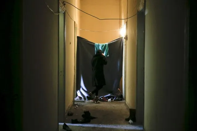 A woman stands in a corridor at Idomeni train station where refugees and migrants find shelter at the Greek-Macedonian border near the village of Idomeni, Greece, March 19, 2016. (Photo by Alkis Konstantinidis/Reuters)