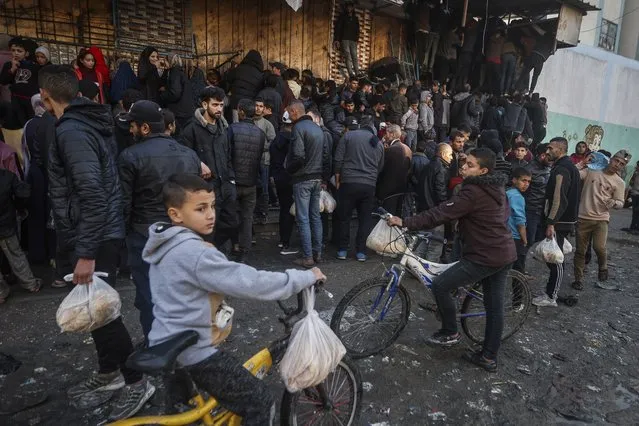 Palestinian crowds struggle to buy bread from a bakery in Rafah, Gaza Strip, Monday, February 19, 2024. International aid agencies say Gaza is suffering from shortages of food, medicine and other basic supplies as a result of the war between Israel and Hamas. (Photo by Mohammed Dahman/AP Photo)
