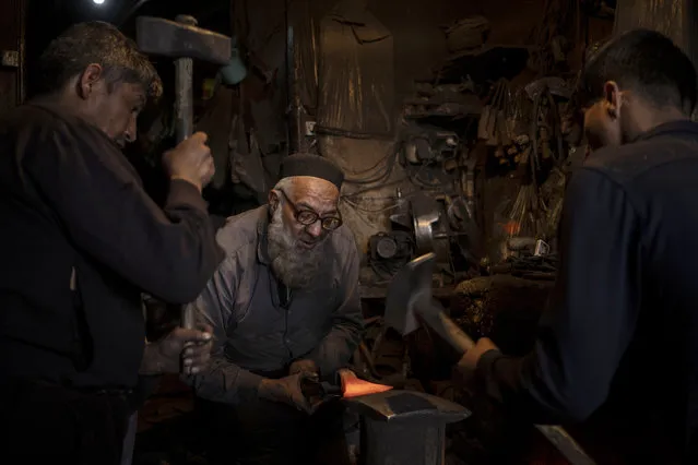 Blacksmith Haji Khalil Ullah forges an axe head in Kabul, Afghanistan on Tuesday, November 9, 2021. (Photo by Bram Janssen/AP Photo)