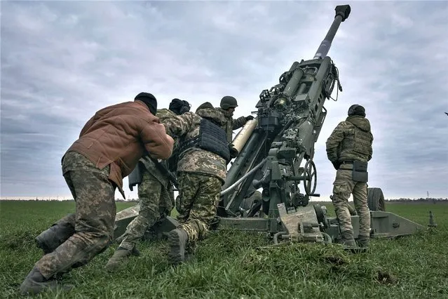 Ukrainian soldiers prepare a U.S.-supplied M777 howitzer to fire at Russian positions in Kherson region, Ukraine, January 9, 2023. (Photo by Libkos/AP Photo)