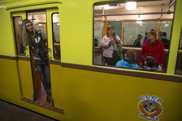 People make pictures in a Soviet-era vintage subway car, with a Soviet railways emblem on the side of it, parked in the Partizanskaya subway station in Moscow, Russia, Friday, May 15, 2015. (Photo by Pavel Golovkin/AP Photo)