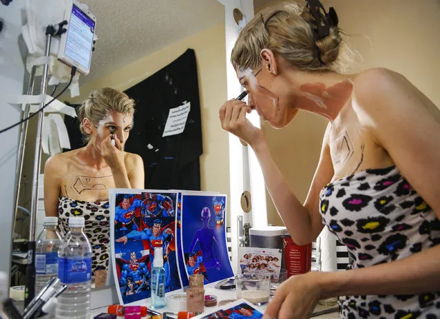 In this March 19, 2016 photo, Kay Pike transforms herself using body paint and latex into Superman while live streaming at her home in Calgary, Alberta. Pike refers to all her creations as her “little paint children”. She said it would be boring and lonely to do the painting without an audience. (Photo by Jeff McIntosh/The Canadian Press via AP Photo)