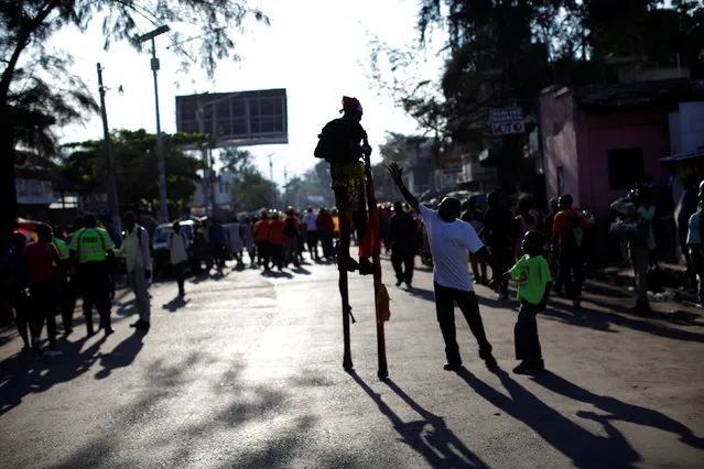 A man greets a reveller walking on stilts before a Carnival parade along a street of Port-au-Prince, Haiti, February 27, 2017. (Photo by Andres Martinez Casares/Reuters)