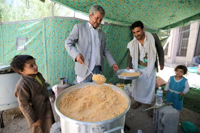 An internally displaced man distributes food at a school in Sanaa May 17, 2015. (Photo by Mohamed al-Sayaghi/Reuters)