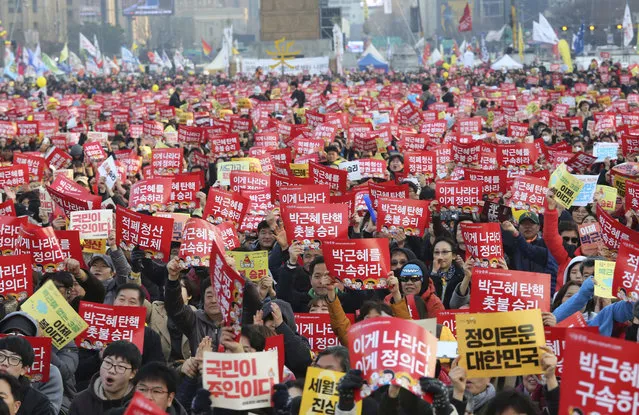 Protesters hold up cards during a rally calling for impeached President Park Geun-hye's arrest in Seoul, South Korea, Saturday, March 11, 2017. South Korean police on Saturday braced for more violence between opponents and supporters of ousted President Park Geun-hye, who was stripped of her powers by the Constitutional Court over a corruption scandal that has plunged the country into a political turmoil. The signs read “Park Geun-hye's arrest”. (Photo by Ahn Young-joon/AP Photo)