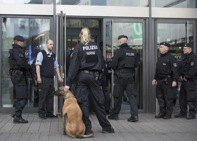 Police guard in front of a shopping mall in Essen, Germany, Saturday, March 11, 2017. Police have ordered the shopping mall in the western German city of Essen not to open after receiving credible tips of an imminent attack. The shopping center and the adjacent parking lot stayed closed Saturday morning as over a hundred police officers searched the compound. (Photo by Bernd Thissen/DPA via AP Photo)