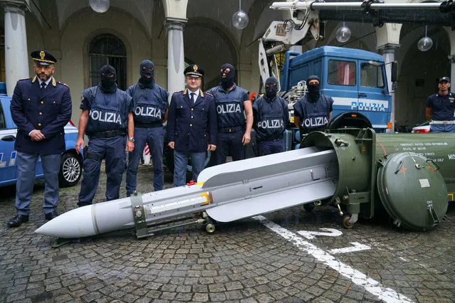 Police stand by a missile seized at an airport hangar near Pavia, northern Italy, following an investigation into Italians who took part in the Russian-backed insurgency in eastern Ukraine, in Turin, Italy, Monday, July 15, 2019. Police in northern Italy have detained three men, including one tied to a neo-fascist Italian political party, after uncovering a huge stash of automatic weapons, a missile and Nazi propaganda. (Photo by Tino Romano/ANSA via AP Photo)