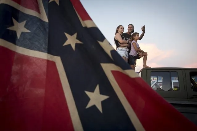 A family stands on the back of their pickup truck as they take part in the “Ride for Pride” impromptu event to show their support the Confederate flag in Brandon, Hillsborough County, June 26, 2015. (Photo by Carlo Allegri/Reuters)
