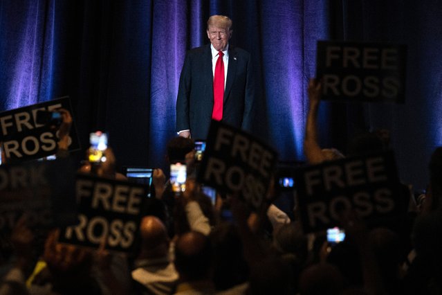 People hold up signs reading "Free Ross" as former US President and Republican presidential candidate Donald Trump arrives to address the Libertarian National Convention in Washington, DC, May 25, 2024. Ross Ulbricht, the founder of the online marketplace Silk Road for the sale of heroin, cocaine, LSD and other illegal drugs, was sentenced to life in prison in 2015. (Photo by Jim Watson/AFP Photo)