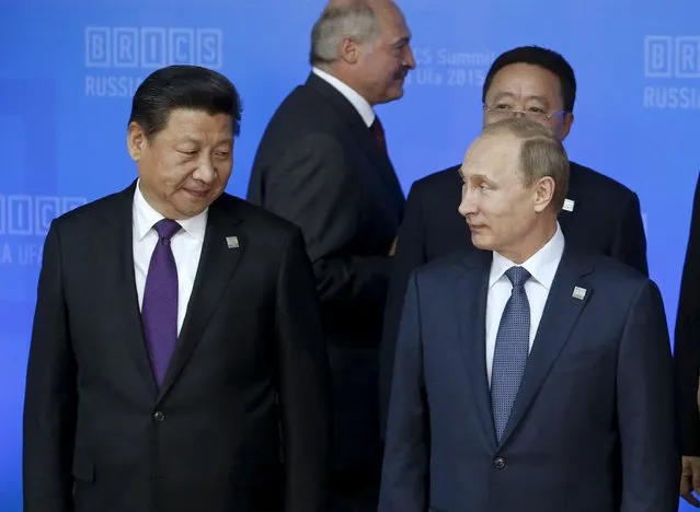 Russia's President Vladimir Putin (R) and China's President Xi Jinping arrive for a family photo session with leaders of the invited states during the BRICS Summit in Ufa, Russia, July 9, 2015. Ufa hosts the BRICS and the Shanghai Cooperation Organization (SCO) summits on July 9-10. (Photo by Sergei Karpukhin/Reuters)