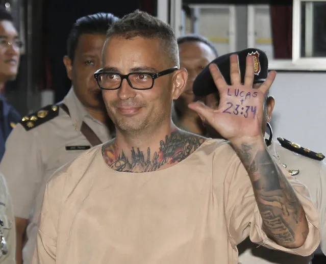 Artur Segarra Princep of Spain raises his hand displaying a popular Bible verse on the palm of his hand reading, “Lucas 23:34” as he arrives at the criminal court in Bangkok, Thailand, Friday, April 21, 2017. A Thai court has sentenced to death a Spanish man after finding him guilty of murder in the gruesome death of a fellow Spaniard. (Photo by Sakchai Lalit/AP Photo)