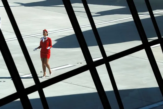 A worker in period flight attendant costume is seen through a window of the main lobby of the TWA Hotel, which is housed inside the former 1962 TWA Flight Center terminal which was designed by architect Eero Saarinen at JFK International Airport in New York, U.S., October 2, 2019. (Photo by Mike Segar/Reuters)