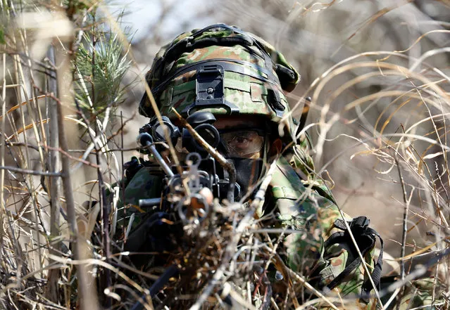 A member of the Japanese Self-Defense Force’s Amphibious Rapid Deployment Brigade aims his gun as he takes a position during joint airborne landing exercises with the U.S.Marine Corps near Mount Fuji at Higashifuji training field in Gotemba, west of Tokyo, Japan on March 15, 2022. (Photo by Kim Kyung-Hoon/Reuters)
