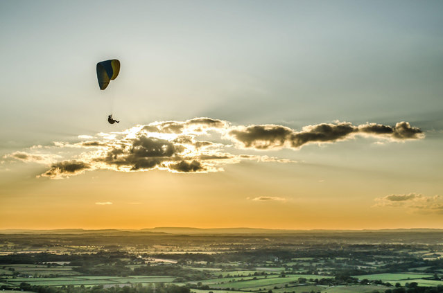 Paragliding at sunset on the South Downs, England in the first decade of June 2024. (Photo by David Burr/Alamy Live News)