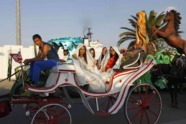 Tunisian girls in traditional Sefsari costumes sit on a horse carriage during the Aoussou Carnival in Sousse, Tunisia July 26, 2015. (Photo by Anis Mili/Reuters)