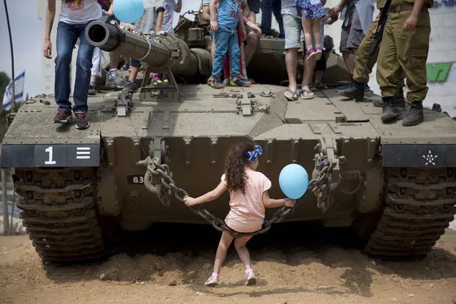 Israeli children play on an army tank displayed by the Israeli military as part of Independence Day celebrations, in Givatayim, near Tel Aviv, Israel, Tuesday, May 2, 2017. Israel is celebrating 69 years since the modern Jewish state was formed. (Photo by Ariel Schalit/AP Photo)