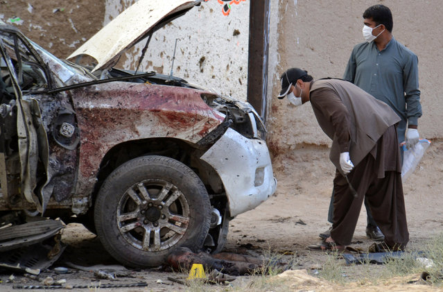 Security officers collect evidence as they investigate crime scene after a bomb exploded next to a convoy of deputy chairman of the Pakistan Senate, Senator Ghafoor Haideri in Mastung, Pakistan, May 12, 2017. (Photo by Naseer Ahmed/Reuters)