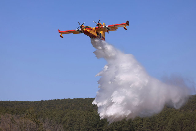 A plane drops water to combat the Hermits Peak and Calf Canyon wildfires, near Las Vegas, New Mexico, U.S. May 4, 2022. (Photo by Kevin Mohatt/Reuters)