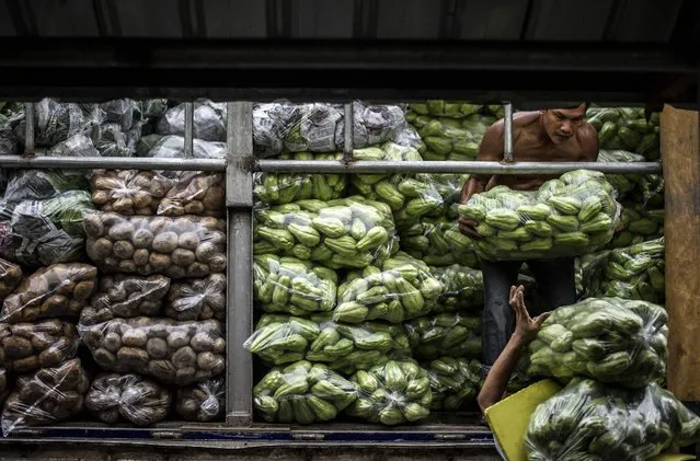 Workers help each other carry vegetables in Divisoria Market in Manila on June 8, 2016. The Philippines' economy grew a better-than-expected 6.9 percent in the first quarter, the government said, putting it on track to meet full year targets and making it one of Asia's best performers for the three month period. (Photo by Noel Celis/AFP Photo)
