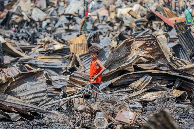 A boy is seen as he searches for useful stuff from his charred home a day after a slum area fire in Cavite Province, the Philippines on September 11, 2024. (Photo by Rouelle Umali/Xinhua/Alamy Live News)