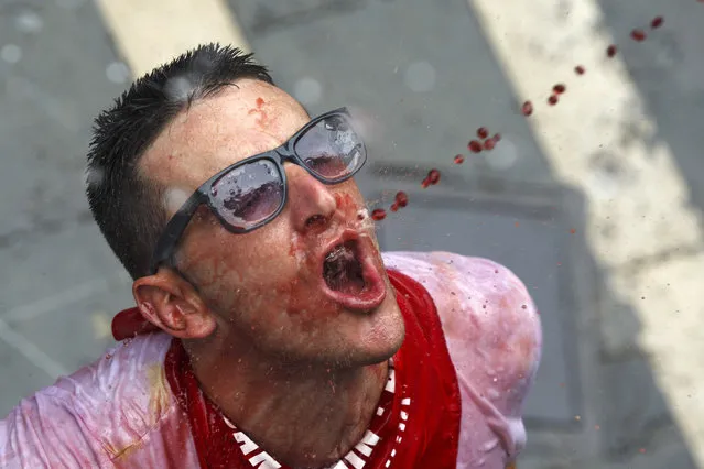 A reveller catches wine thrown from a balcony during the opening day or “Chupinazo” of the San Fermin Running of the Bulls fiesta on July 6, 2017 in Pamplona, Spain. (Photo by Pablo Blazquez Dominguez/Getty Images)