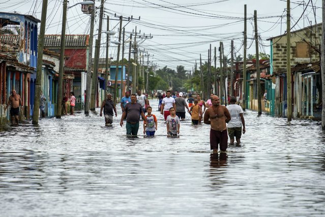 Residents wade through a street flooded in the passing of Hurricane Helene, in Batabano, Mayabeque province, Cuba, Thursday, September 26, 2024. (Photo by Ramon Espinosa/AP Photo)