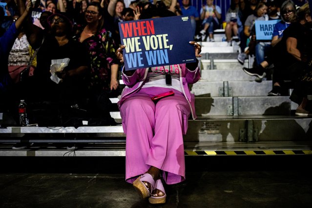 An atendee holds a sign during a camaign event with former U.S. President Barack Obama as he continues to campaign for Democratic presidential nominee and U.S. Vice President Kamala Harris during the first week of early voting in Detroit, Michigan, U.S. October 22, 2024. (Photo by Emily Elconin/Reuters)