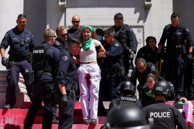 A woman reacts as she and other three are detained from where they lie in paint protesting to the overturning of Roe vs. Wade in front of City Hall, in Los Angeles, California, U.S., July 6, 2022. (Photo by David Swanson/Reuters)