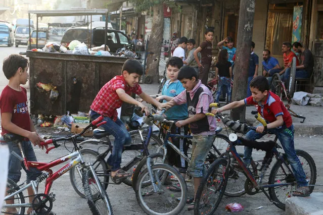 Boys on bicycles gather in the rebel held area of Aleppo's al-Shaar district, Syria, June 27, 2016. (Photo by Abdalrhman Ismail/Reuters)