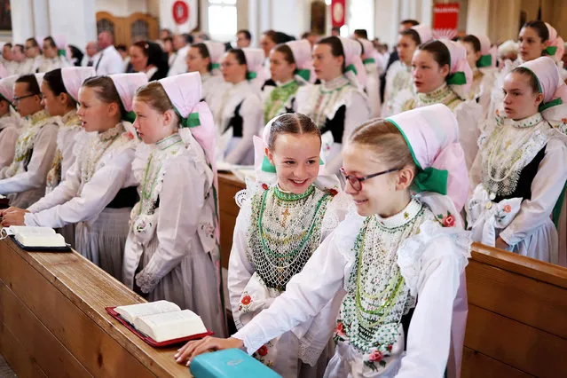 Girls, wearing traditional Sorbian festive dress known locally as “druzka”, attend the annual Sorbian Corpus Christi Catholic mass prior to leading a procession on June 16, 2022 in Crostwitz, Germany. Sorbians are a Slavic minority in southeastern Germany who speak a language similar to Czech and Polish. Sorbian is still taught in some schools in the region and a lively tradition of Sorbian literature, theater and folk culture has survived. (Photo by Sean Gallup/Getty Images)