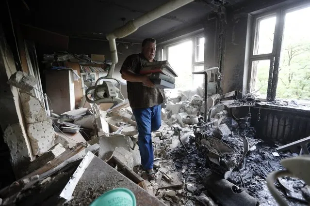A man inspects wreckage inside a damaged building following what locals say was shelling by Ukrainian forces in Donetsk August 7, 2014. The Ukrainian government said on Thursday it was suspending a ceasefire with separatist rebels at the crash site of the Malaysian airliner after an international recovery mission had been halted. (Photo by Sergei Karpukhin/Reuters)