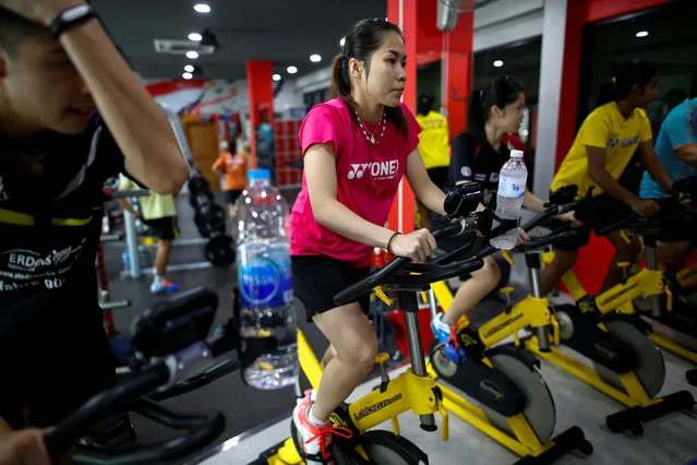 Thailand's badminton player Ratchanok Intanon (C), who hopes to win gold at the Rio Olympics, rides a fitness bike during a training session at a gym in Bangkok, Thailand, June 22, 2016. (Photo by Athit Perawongmetha/Reuters)