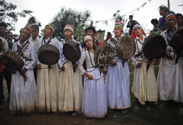 Nepalese witch doctors play their drums  and offer prayers to Lord Shiva, the Hindu god of destruction during Janai Purnima festival in Timal village, Kavre district, Nepal, Saturday, August 29, 2015. During this festival Hindus take holy baths and perform their annual change of the Janai, a sacred cotton string worn around their chest or tied on the wrist, in the belief that it will protect and purify them. (Photo by Niranjan Shrestha/AP Photo)