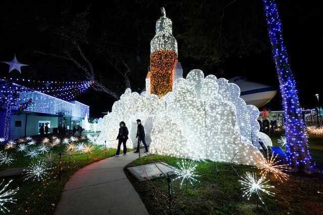 People walk among space-themed holiday lights at Space Center Houston on Monday, December 9, 2024, in Houston. (Photo by Ashley Landis/AP Photo)