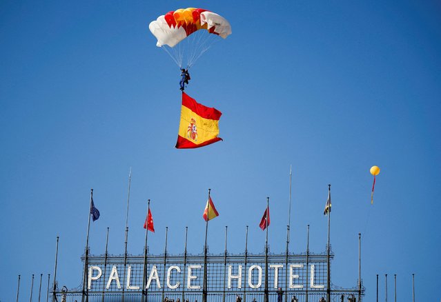 A skydiver waving Spain's flag attends a military parade to mark Spain's National Day, in Madrid, Spain on October 12, 2023. (Photo by Juan Medina/Reuters)