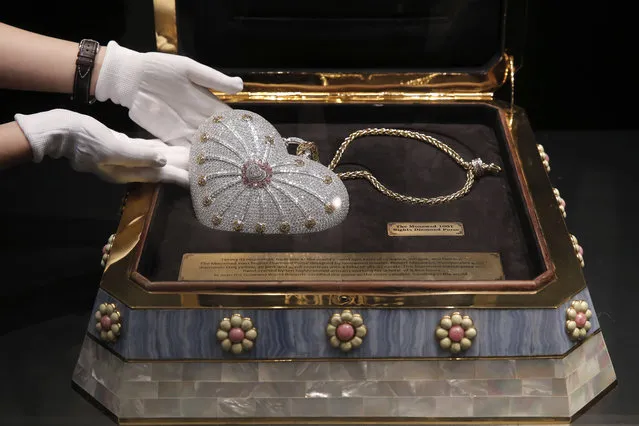 A staff member from the Christie's Hong Kong, displays a heart-shaped handbag, the Mouawad “1001 Nights Diamond Purse” which incorporated 4,517 diamonds with a total weight of 381.92 carats during an auction preview in Hong Kong, Tuesday, October 17, 2017. The handbag was set the Guinness World Records in 2010 for the most valuable handbag in the world. (Photo by Kin Cheung/AP Photo)