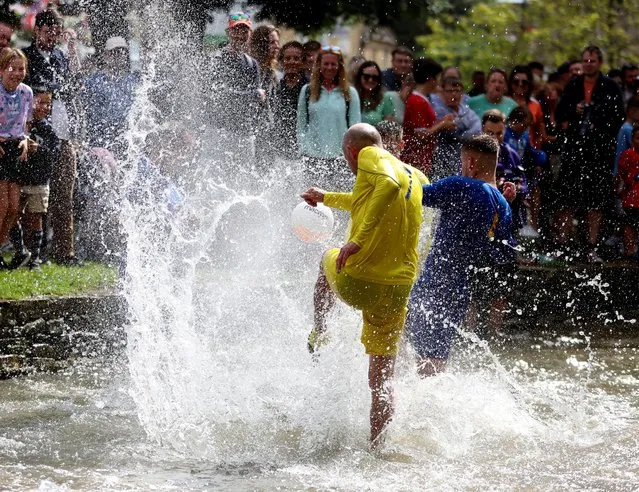 People compete in the annual football match in the River Windrush in Bourton-on-the-Water, Gloucestershire, Britain on August 29, 2022. (Photo by Lee Smith/Reuters)