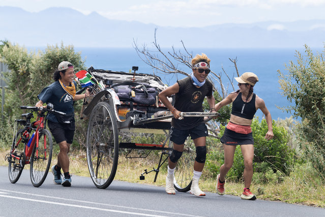 Gump Suzuki, the Japanese runner and social media sensation who started in July 2024 an overland journey of 6400km from Kenya to South Africa, is helped by friends to push his rickshaw near Simon's Town, on January 24, 2025 as he nears his trip to the South Western tip of Africa. The 34-year-old tour guide from Tokyo has also done similar adventures on other continents, and wears contemporary version of traditional Japanese Tabi shoes. (Photo by Rodger Bosch/AFP Photo)
