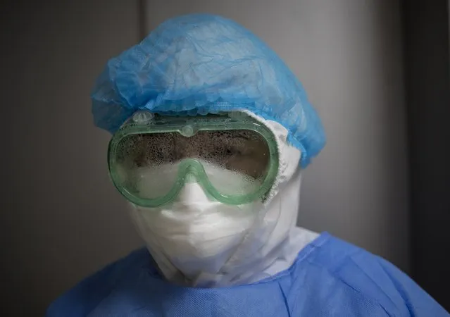 A cleaning woman eyes the camera through her fogged up goggles, inside the intensive care unit for COVID-19, at the Guillermo Almenara hospital in Lima, Peru, Friday, May 22, 2020. Despite strict measures to control the virus, this South American nation of 32 million has become one of the countries worst hit by the disease. (Photo by Rodrigo Abd/AP Photo)